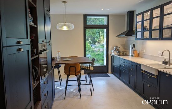 Aménagement d'une cuisine classique chic noire avec rangement optimisés, réalisée par Espace Opal'in à Angers.